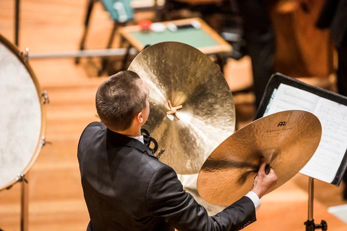 Sehen Sie hier ein Orchestermitglied bei der Erzeugung lauter Geräusche